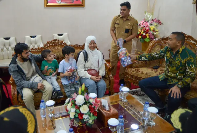Plt Gubernur Sumbar Audy Joinaldy (kanan) memberikan hadiah kepada anak dari Warga Negara Indonesia (WNI) dari Lebanon setibanya di Bandara Internasional Minangkabau (BIM) Padang Pariaman, Sumatera Barat, Selasa (15/10).