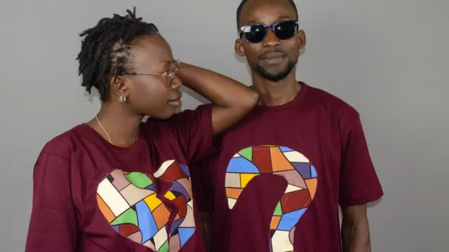Fatou Sene (G) et un modele homme portent un tee-shirt de sa ligne de vêtements, Naya