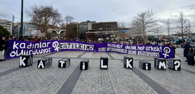 Beşiktaş Meydanı'nda pankart açan kadınlar. Önde "Katil kim?" yazıyor