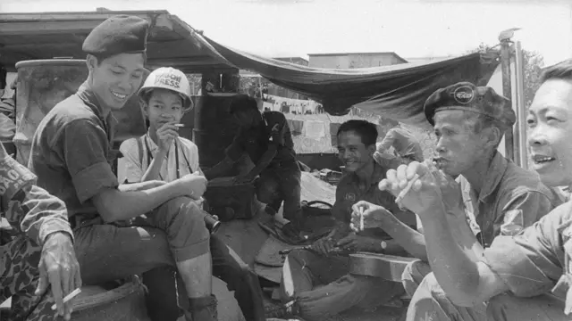 Jimmy fuma cigarro com soldados em um acampamento