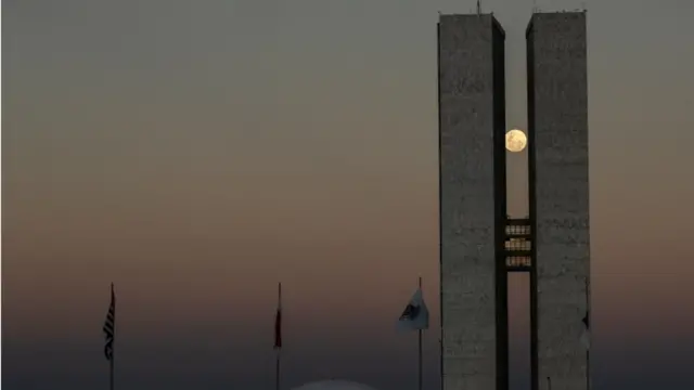 Staying in South America, this picture shows the super moon peaking between the two towers of the National Congress building, in Brasilia, Brazil.
