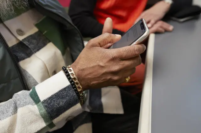 মোবাইল ফোন দেখছেন এক ব্যক্তি