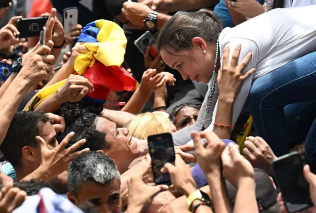 A líder da oposição venezuelana María Corina Machado cumprimenta apoiadores durante um evento de campanha