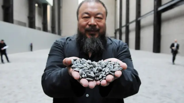 Ai Weiwei segurando sementes de girassol