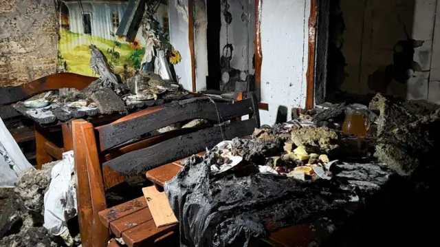 сгоревший ресторан: обугленные скамьи и столы, поврежденные стены