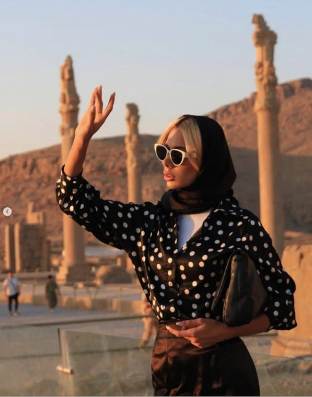 تورلان در تخت جمشید با عینک آفتابی و پیراهن خال دار مشکی و سفید