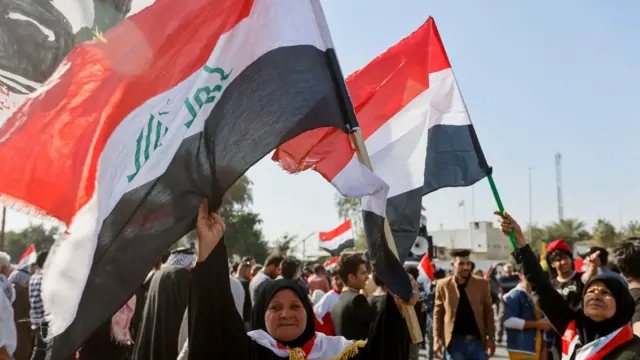 يلوح المتظاهرون بالأعلام احتجاجًا على التعديلات المقترحة على قانون الانتخابات، قرب البرلمان العراقي في بغداد، العراق، 27 فبراير/شباط 2023