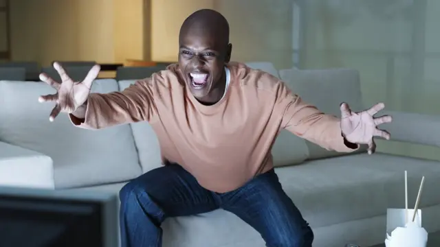 hombre mostrando euforia frente al televisor