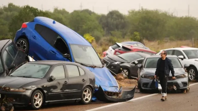 یک جاده در اسپانیا با خودروهایی که پس از سیلاب انباشته شده 