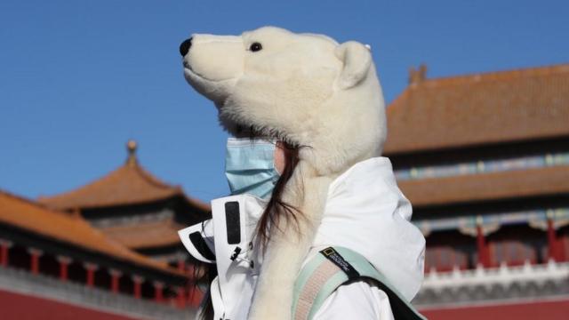 1月6日，一名游客戴着一顶熊形保暖帽参观北京故宫。