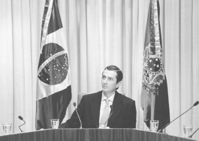 Foto em preto e branco com Fernando Collor fazendo um pronunciamento enquanto era presidente da República