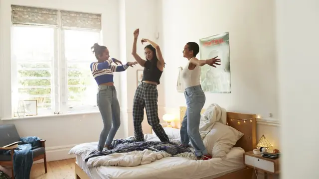 Amigas saltando en la cama