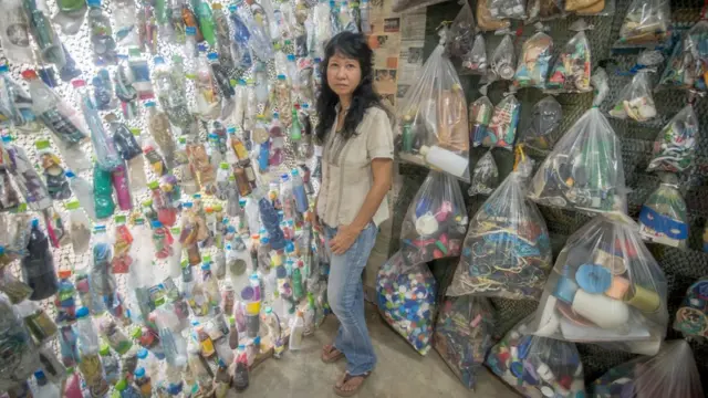 ประสพสุข ยืนอยู่หน้าผลงานชื่อ How to choke a planet