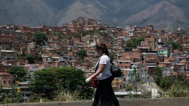 Mujer caminando con Petare en el fondo.