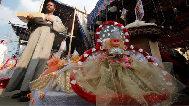 A vendor selling traditional sweets and "Aroset El Moulid" (Bride of Moulid) dolls waits for customers at a market ahead of the religious holiday of Mawlid al-Nabi, the birthday of Prophet Mohammad, in Old Cairo, Egypt December 8, 2016