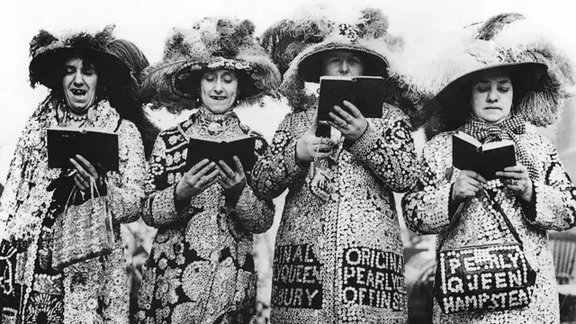 Четири жене обучене у раскошним костимима са шеширима од перја