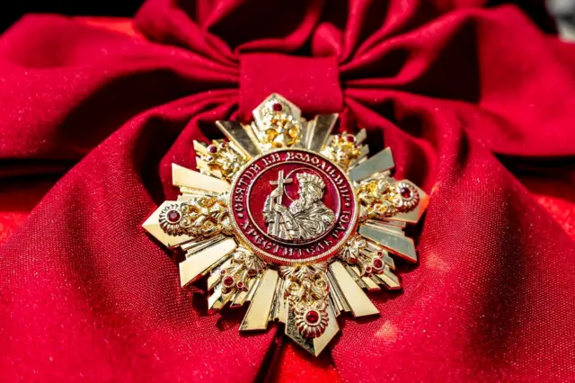 Фото ордену князя Володимира на червоному тлі
