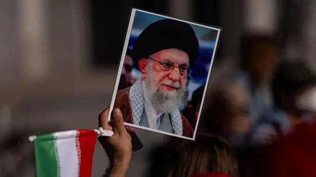 Un manifestante con un retrato del líder supremo de Irán, el ayatolá Alí Jamenei, protesta en Los Ángeles, California. 