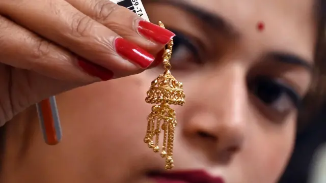 Gold earing in a woman's hand