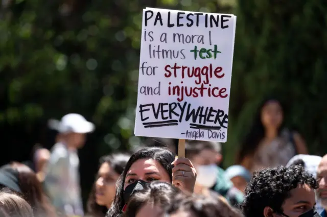 Una manifestante propalestina sostiene una pancarta en el campus de UCLA en Los Ángeles en 29 de abril de 2024.
