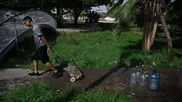 Persona cargando agua.