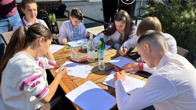 Les six enfants dessinent à une table