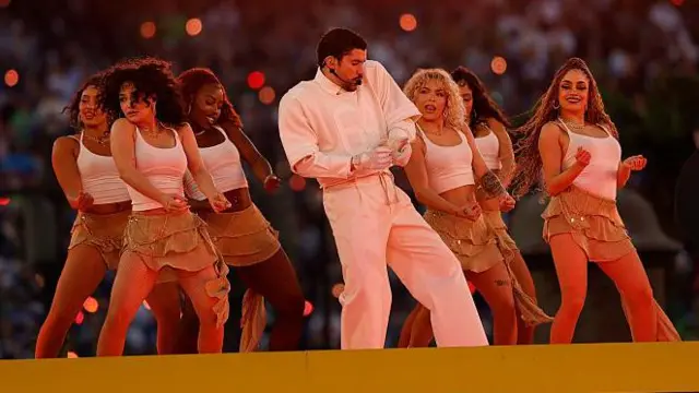 Bad Bunny cantando y bailando durante su show. 