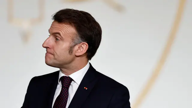 Prezydent Francji Emanuel Macron, mężczyzna po pięćdziesiątce, o krótkich włosach w ciemnym garniturze.