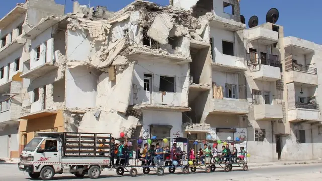 Suriye'nin İdlib eyaletinde çocuklar Kurban Bayramı'nda balonlarla süslenmiş araçla gezdiriliyorlar (1 Eylül 2017)