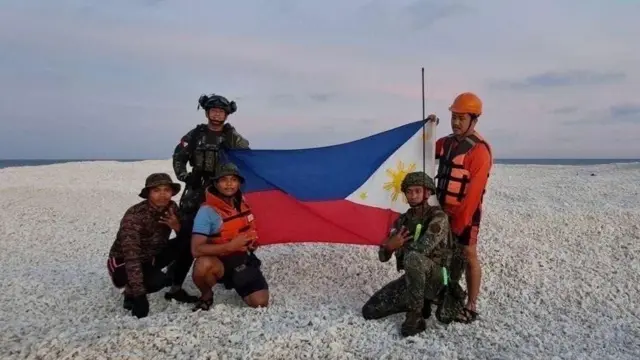 南シナ海の砂州でフィリピン国旗を掲げるフィリピン当局者