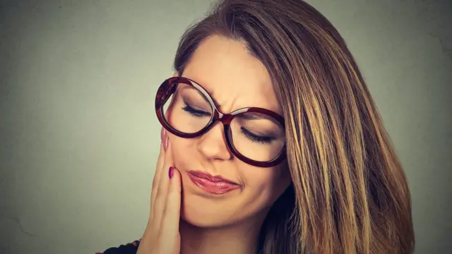 Mujer con dolor en la boca.