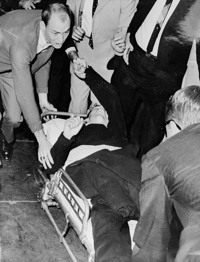 Oswald es llevado en camilla a una ambulancia tras ser baleado por Jack Ruby
