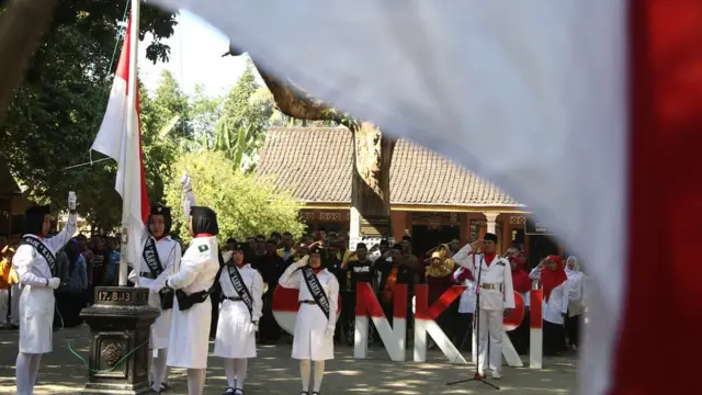 Petugas mengibarkan bendera Merah Putih di Situs Persada Soekarno, Kediri, Jawa Timur, Jumat (17/08). Situs Persada Soekarno adalah rumah masa kecil sang proklamator kemerdekaan Indonesia.