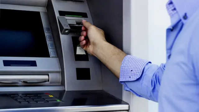 एटीएम से पैसे निकालता एक आदमी
