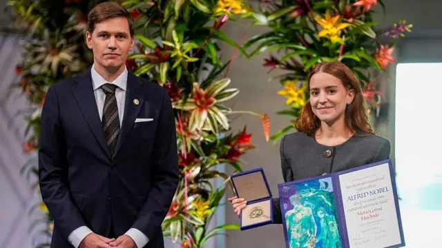 La hija de maría corina machado, ana corina sosa machado, sostiene el premio nobel de la paz. 