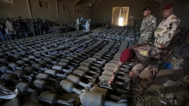 Oficiales iraquíes inspeccionan municiones de EI en Faluya.