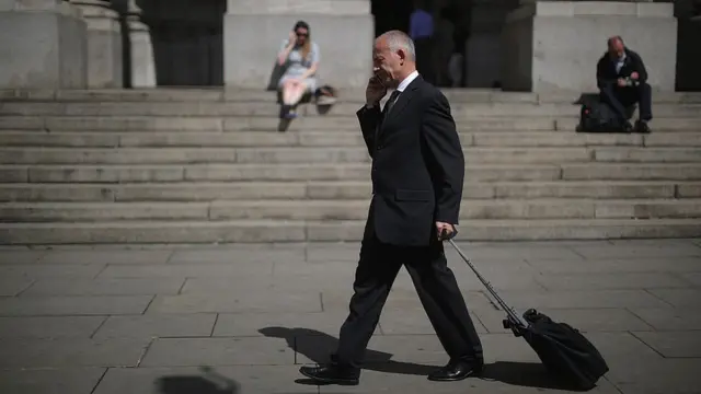 Работник Сити с чемоданом и мобильным