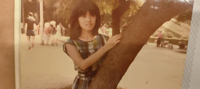 1980年代，一位台湾美宁女员工依傍在树旁拍照留念（白丽萍提供图片）