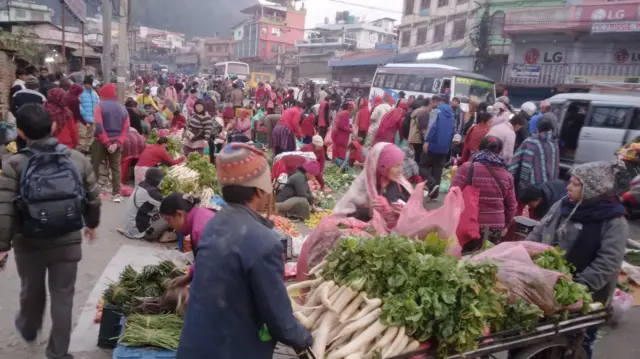 बजारमा तरकारी किन्दै मानिसहरू