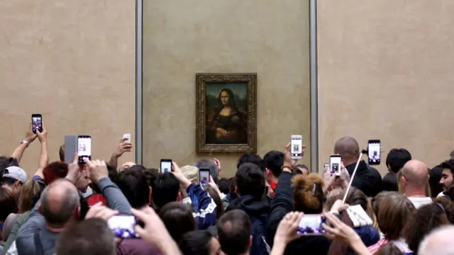 La Mona Lisa de Leonardo da Vinci siendo fotografiada con celulares en el Museo Louvre.