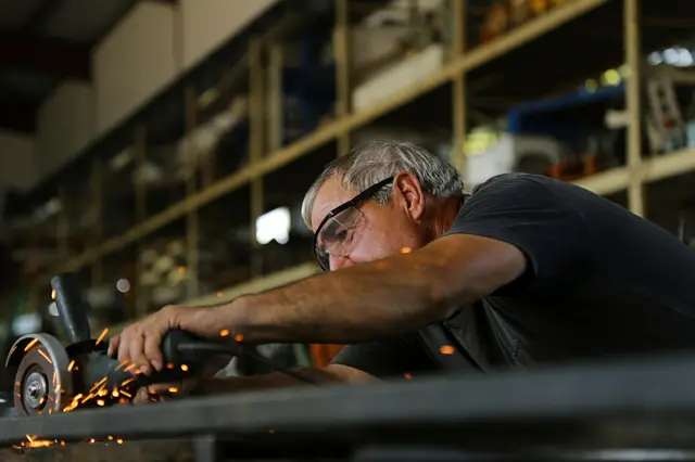 Kaynak yapan ileri yaşlı bir erkek çalışan. 