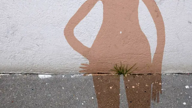 Street art by Sandrine Boulet shows a female contour drawn around grass on a pavement