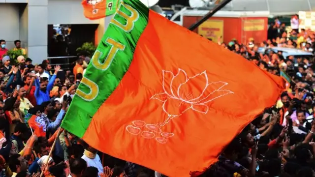 Supporters wave a BJP flag at a rally in 2022