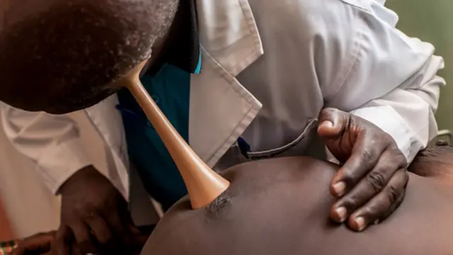 A doctor checks foetal heart rate in a pregnant woman
