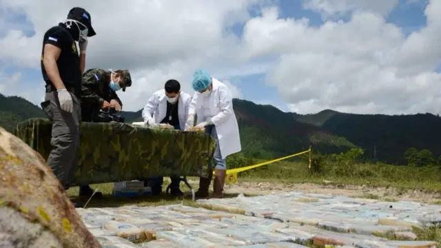 Policiais analisando drogas