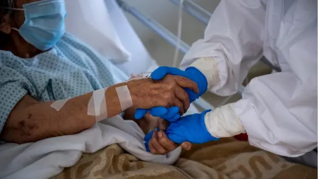 ROME, ITALY - APRIL 14: (EDITORIAL USE ONLY) A medical worker greets a patient suffering from COVID-19 in an intensive care unit (ICU) in the Covid department of Rome's San Filippo Neri Hospital on April 14, 2020, in Rome, Italy. There have been well over 160,000 reported coronavirus (COVID-19) cases in Italy and more than 20,000 related deaths, but the officials are confident the peak of new cases has passed.