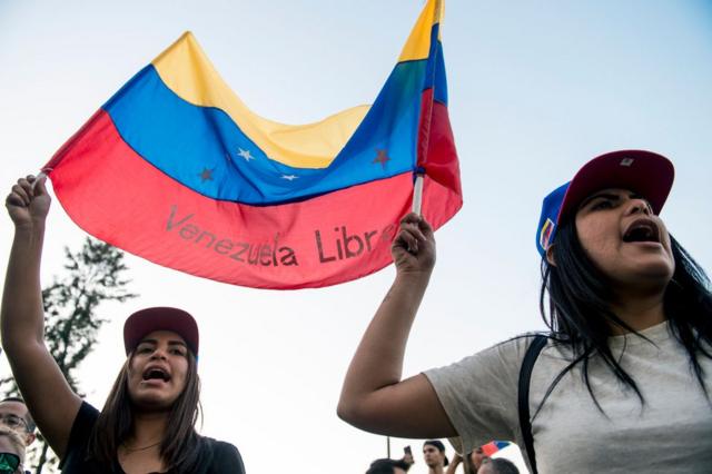 Venezuelan citizens living in Chile shout slogans during a demonstration against president Nicolas Maduro"s government in Santiago, Chile, on April 30, 2019