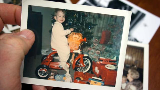 Fotografía de un niño en un triciclo en Navidad.