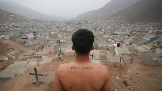 Sepulturero mira hacia un cementerio en las afueras de Lima, Perú.