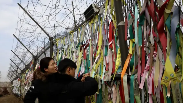 দুই কোরিয়ার মধ্যে শান্তি ও ঐক্য কামনা করে সীমান্তে কাঁটাতারের বেড়ায় ফিতে ঝুলিয়ে রাখা রয়েছে।